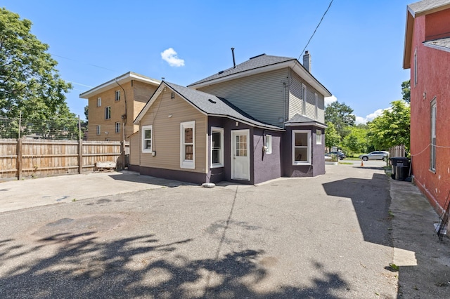 2804 Pillsbury Ave S, Minneapolis, MN 55408 - back of house featuring a chimney, roof with shingles, and a patio