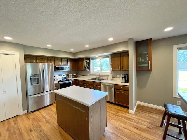 402 Range Rd, Springfield, MN 56087 - kitchen with appliances with stainless steel finishes, a textured ceiling, light wood-style floors, light countertops, and a kitchen island