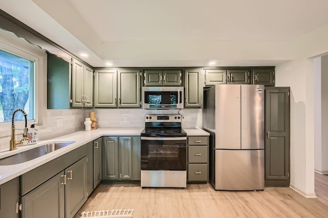 8222 Brandywine Pkwy, Brooklyn Park, MN 55444 - kitchen featuring appliances with stainless steel finishes, light countertops, backsplash, light wood finished floors, and recessed lighting