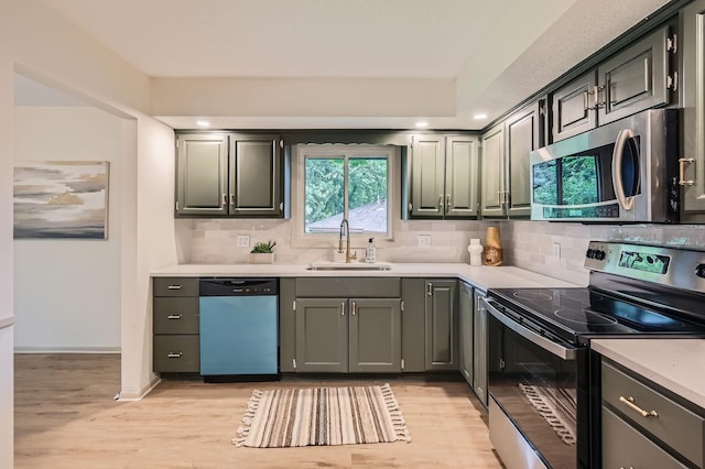 8222 Brandywine Pkwy, Brooklyn Park, MN 55444 - kitchen featuring appliances with stainless steel finishes, light wood-style flooring, light countertops, backsplash, and recessed lighting