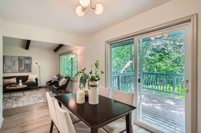 8222 Brandywine Pkwy, Brooklyn Park, MN 55444 - dining space with plenty of natural light, a chandelier, light wood-style floors, and beamed ceiling