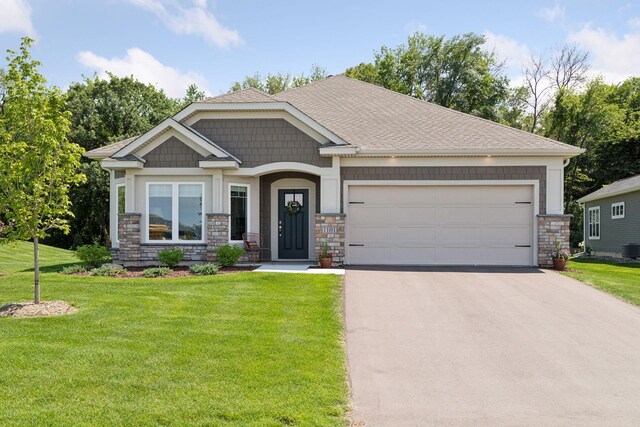 1101 Fabel Ln, Waconia, MN 55387 - craftsman house featuring asphalt driveway, stone siding, a garage, a front yard, and roof with shingles