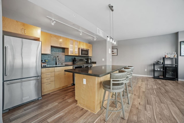 8151 33rd Ave S Unit 201, Bloomington, MN 55425 - kitchen featuring appliances with stainless steel finishes, light brown cabinets, a center island, and wood finished floors