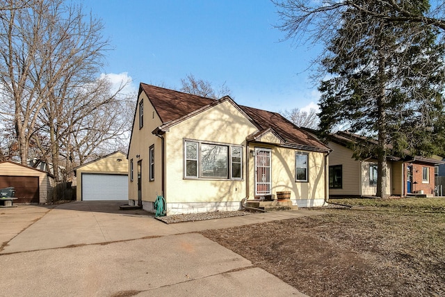 2074 Mcknight Rd N, North Saint Paul, MN 55109 - view of front of property featuring an outdoor structure, a garage, stucco siding, and a shingled roof