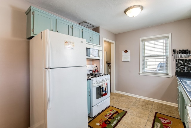 2074 Mcknight Rd N, North Saint Paul, MN 55109 - kitchen featuring white appliances, light tile patterned floors, blue cabinetry, and dark countertops
