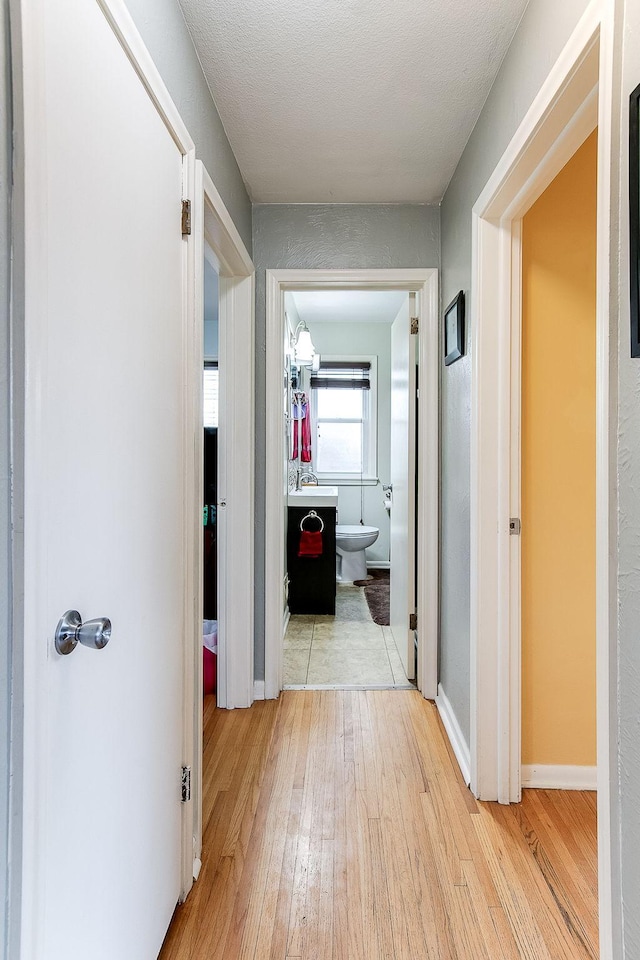 2074 Mcknight Rd N, North Saint Paul, MN 55109 - corridor featuring light wood-type flooring and a sink