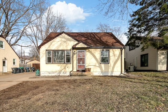 2074 Mcknight Rd N, North Saint Paul, MN 55109 - view of front of home with stucco siding, roof with shingles, and an outbuilding