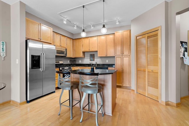500 Grant St Unit 2109, Minneapolis, MN 55404 - kitchen with appliances with stainless steel finishes, light wood finished floors, dark countertops, and a kitchen island