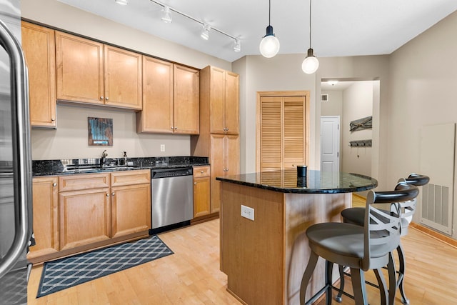 500 Grant St Unit 2109, Minneapolis, MN 55404 - kitchen with stainless steel dishwasher, light wood-style flooring, a breakfast bar area, refrigerator, and a kitchen island