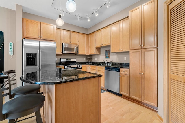 500 Grant St Unit 2109, Minneapolis, MN 55404 - kitchen with appliances with stainless steel finishes, light brown cabinets, light wood finished floors, and a breakfast bar