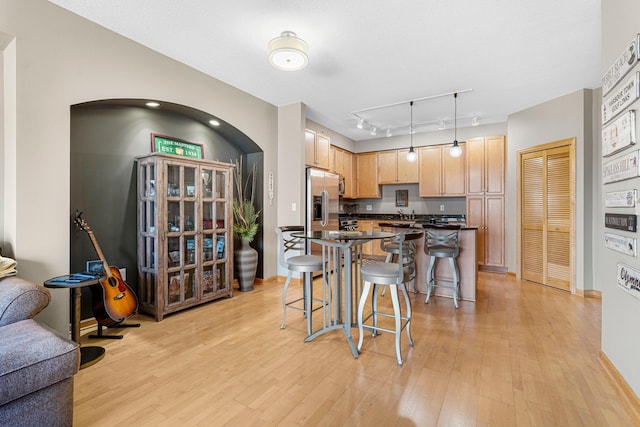 500 Grant St Unit 2109, Minneapolis, MN 55404 - kitchen featuring stainless steel fridge, dark countertops, light wood-type flooring, and a breakfast bar area