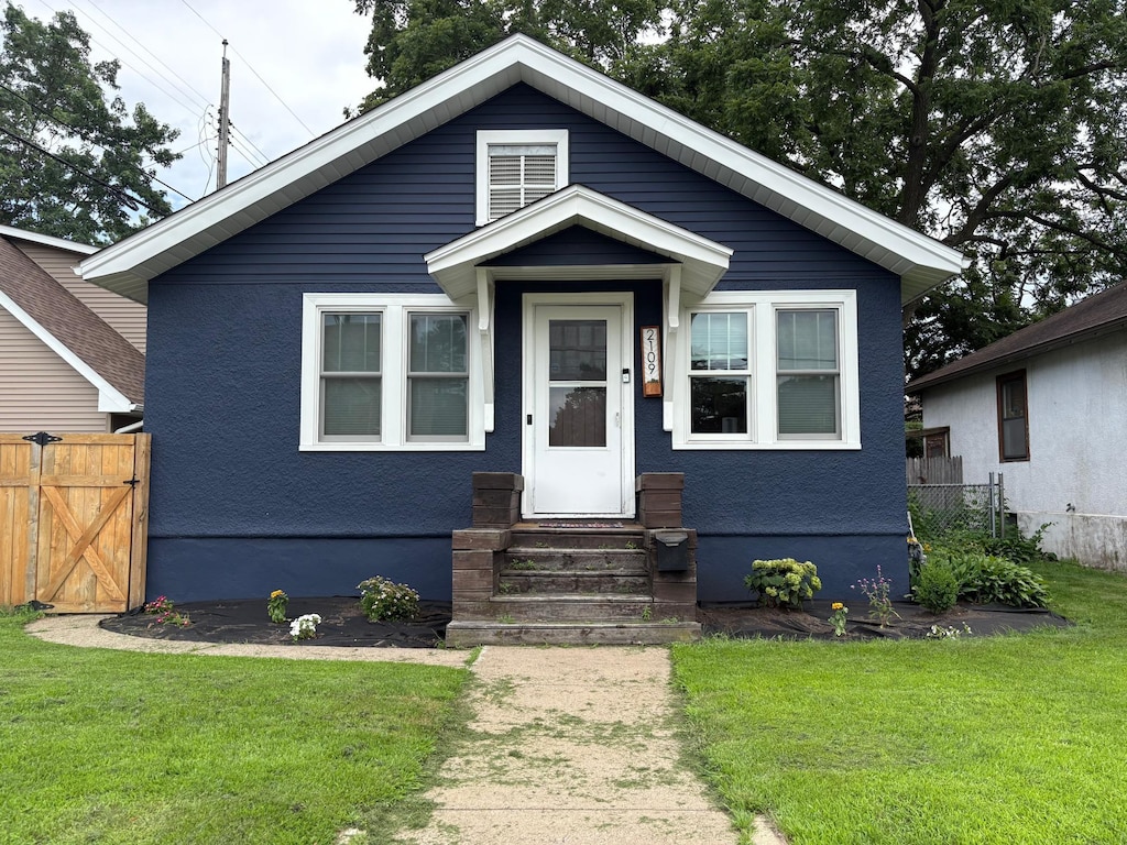 2109 38th St, Minneapolis, MN 55407 - view of front of house with entry steps, a gate, and stucco siding