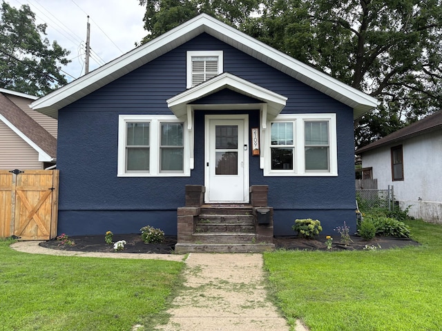 2109 38th St, Minneapolis, MN 55407 - view of front of house with entry steps, a gate, and stucco siding
