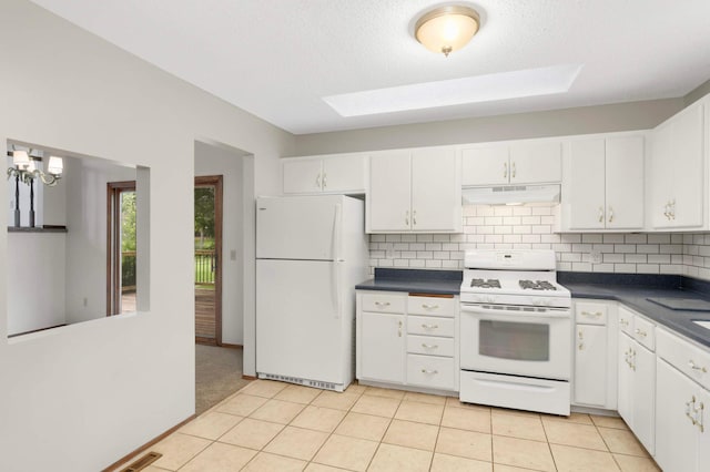 5698 Turtle Lake Rd, Shoreview, MN 55126 - kitchen with white appliances, under cabinet range hood, dark countertops, and white cabinets