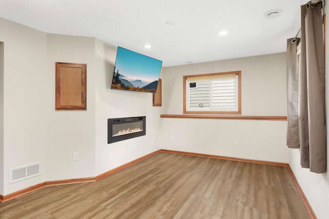 5698 Turtle Lake Rd, Shoreview, MN 55126 - unfurnished living room featuring wood finished floors, a glass covered fireplace, and recessed lighting