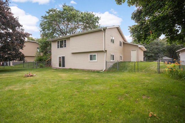 5698 Turtle Lake Rd, Shoreview, MN 55126 - rear view of house with a fenced backyard, a fire pit, and a gate
