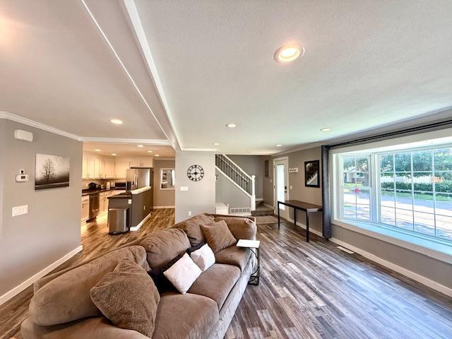 713 Grove St E, Caledonia, MN 55921 - living area featuring stairs, dark wood finished floors, crown molding, and recessed lighting