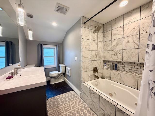 713 Grove St E, Caledonia, MN 55921 - bathroom with marble finish floors, vanity, a combined bath / shower with jetted tub, vaulted ceiling, and recessed lighting