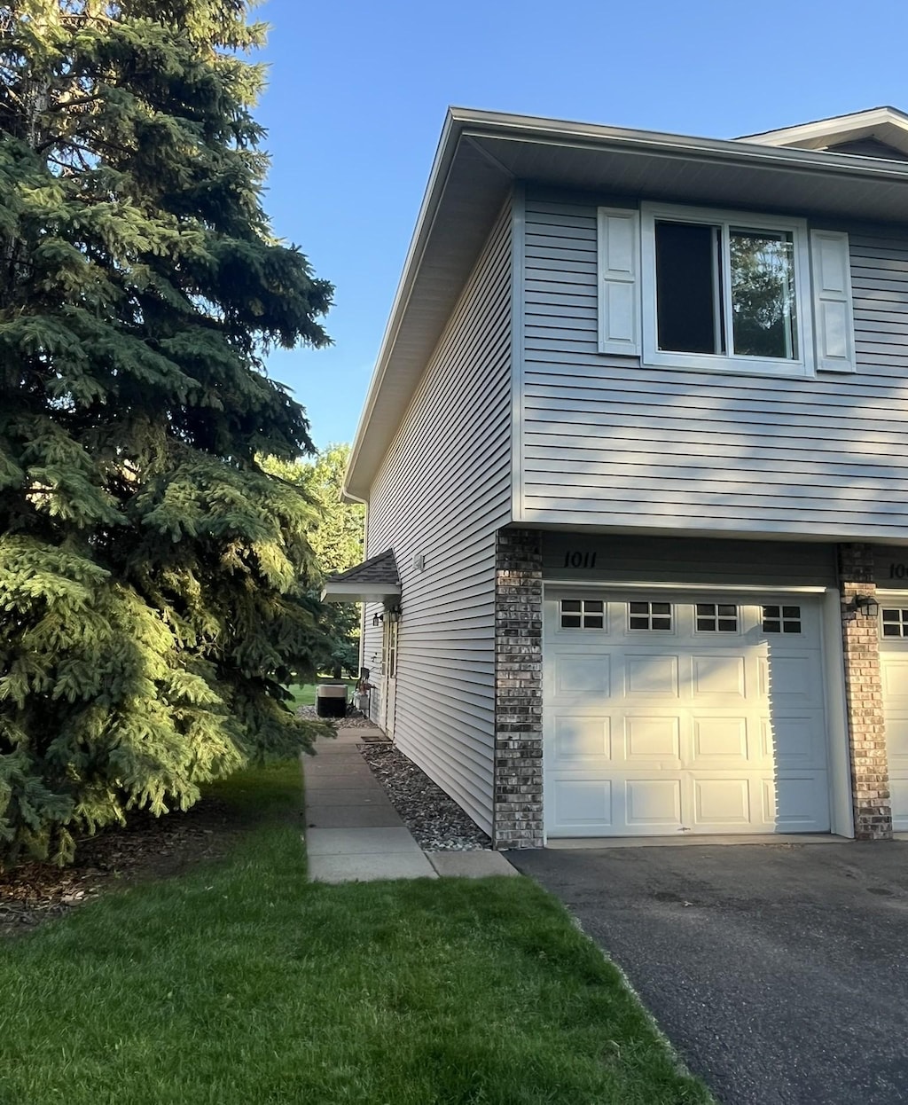 1011 Pond View Ct, Vadnais Heights, MN 55127 - view of side of property with an attached garage, driveway, and stone siding