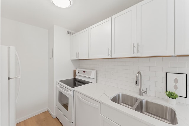 15 1st St Unit A307, Minneapolis, MN 55401 - kitchen with white appliances, white cabinetry, backsplash, light wood-type flooring, and light stone counters