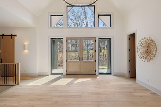 6176 Broadview Ave, Credit River Twp, MN 55372 - foyer featuring high vaulted ceiling, light wood finished floors, a barn door, and a chandelier