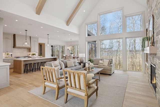 6176 Broadview Ave, Credit River Twp, MN 55372 - living area with high vaulted ceiling, a stone fireplace, beamed ceiling, light wood-style floors, and recessed lighting