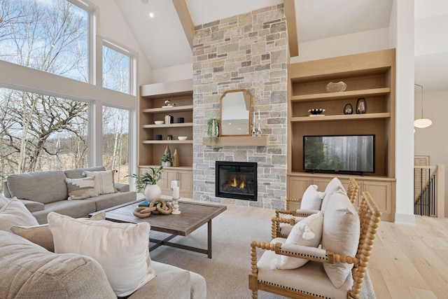 6176 Broadview Ave, Credit River Twp, MN 55372 - living room with high vaulted ceiling, built in features, wood finished floors, and a fireplace