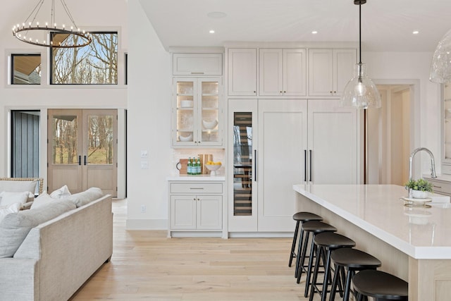 6176 Broadview Ave, Credit River Twp, MN 55372 - kitchen with light wood-style floors, light countertops, a kitchen breakfast bar, hanging light fixtures, and a chandelier