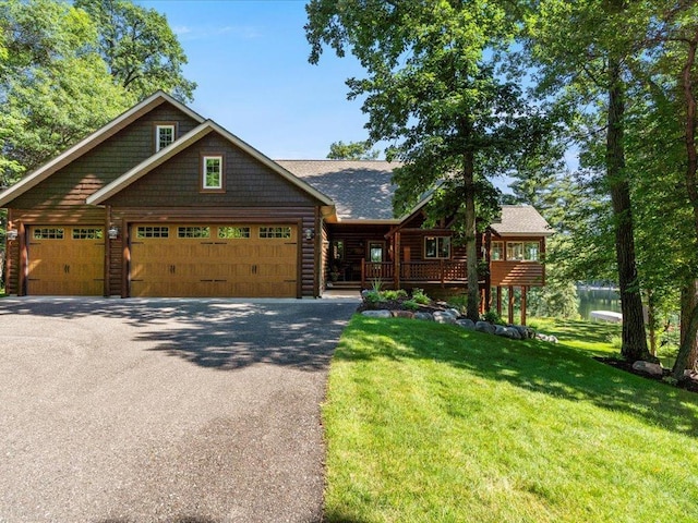 13598 Ox Cove Trl, Crosslake, MN 56442 - view of front facade featuring an attached garage, a front yard, asphalt driveway, and roof with shingles