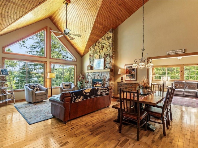 13598 Ox Cove Trl, Crosslake, MN 56442 - dining space featuring high vaulted ceiling, wood ceiling, ceiling fan, a fireplace, and hardwood / wood-style flooring