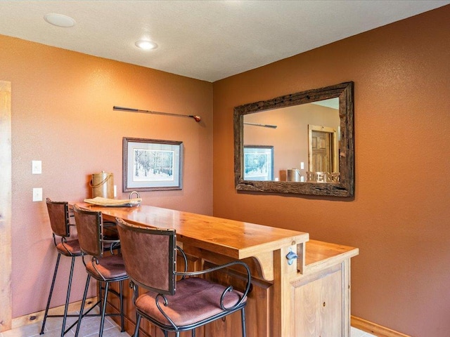 13598 Ox Cove Trl, Crosslake, MN 56442 - tiled dining area featuring baseboards and a dry bar