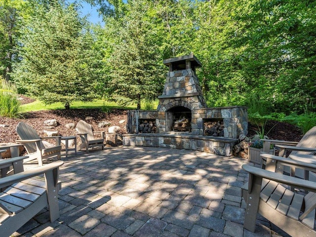 13598 Ox Cove Trl, Crosslake, MN 56442 - view of patio / terrace with an outdoor stone fireplace and a wooded view