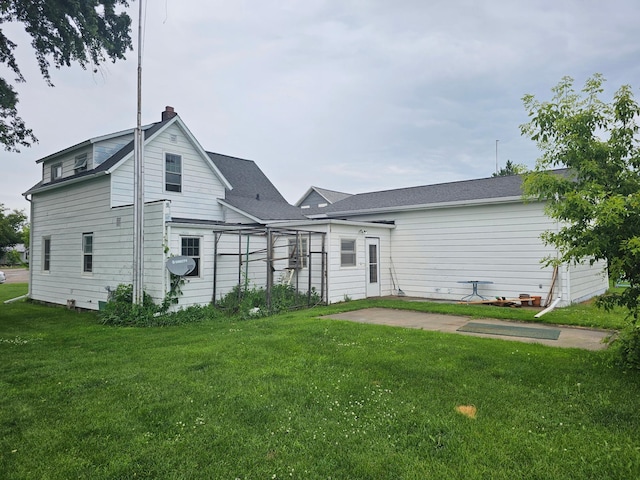 700 Hipple Ave, Henning, MN 56551 - back of house with a yard, a chimney, and a patio area