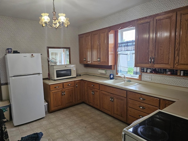 700 Hipple Ave, Henning, MN 56551 - kitchen with freestanding refrigerator, wallpapered walls, a chandelier, range with electric stovetop, and brown cabinetry