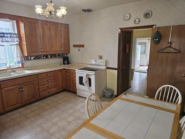 700 Hipple Ave, Henning, MN 56551 - kitchen featuring white range with electric stovetop, wallpapered walls, brown cabinets, and a chandelier