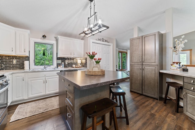 589 Seboe Rd, Wrenshall Twp, MN 55797 - kitchen with a kitchen bar, tasteful backsplash, plenty of natural light, dark wood-type flooring, and lofted ceiling