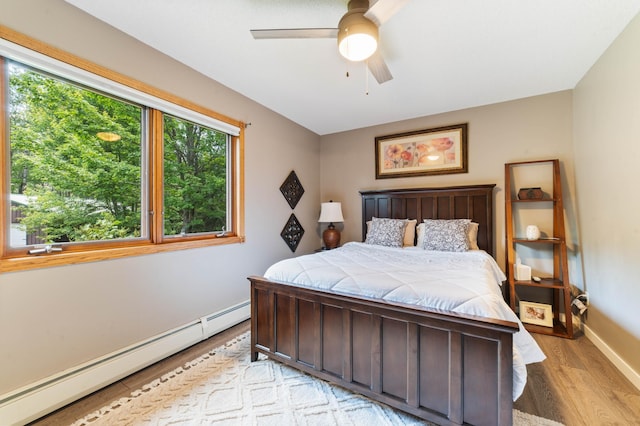 589 Seboe Rd, Wrenshall Twp, MN 55797 - bedroom featuring baseboard heating, light wood finished floors, and ceiling fan