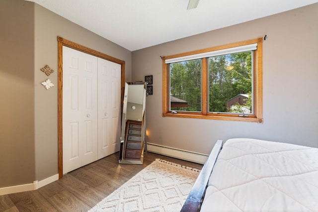 589 Seboe Rd, Wrenshall Twp, MN 55797 - bedroom featuring baseboard heating, wood finished floors, a closet, and ceiling fan