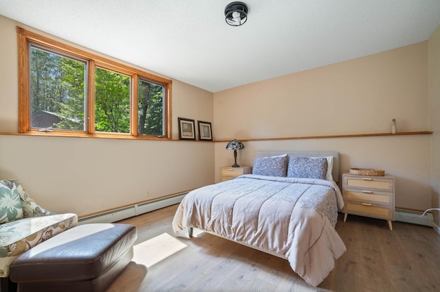 589 Seboe Rd, Wrenshall Twp, MN 55797 - bedroom with a baseboard radiator and wood finished floors