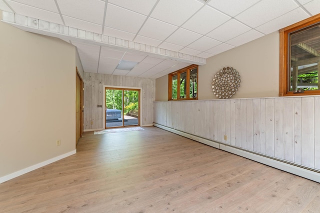589 Seboe Rd, Wrenshall Twp, MN 55797 - unfurnished room featuring a baseboard heating unit, wood finished floors, wood walls, and a drop ceiling