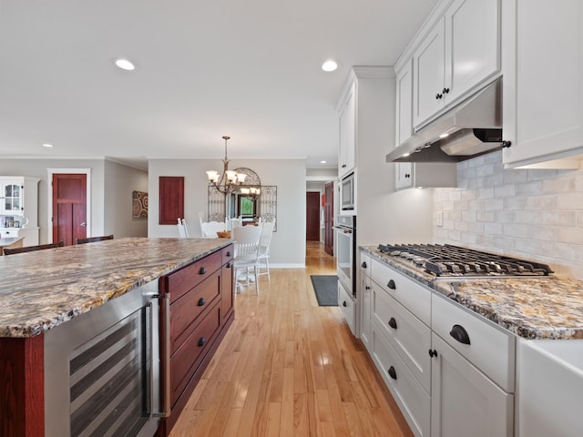 27842 Prairie Rose Rd, Elbow Lake, MN 56531 - kitchen featuring beverage cooler, appliances with stainless steel finishes, under cabinet range hood, a chandelier, and white cabinetry