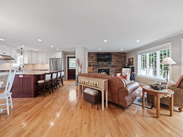 27842 Prairie Rose Rd, Elbow Lake, MN 56531 - living room featuring plenty of natural light, light wood-style floors, a stone fireplace, ornamental molding, and recessed lighting