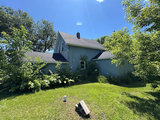 17864 County Road 66 NE, Eagle Bend, MN 56446 - view of side of home with a yard, a chimney, and a shingled roof