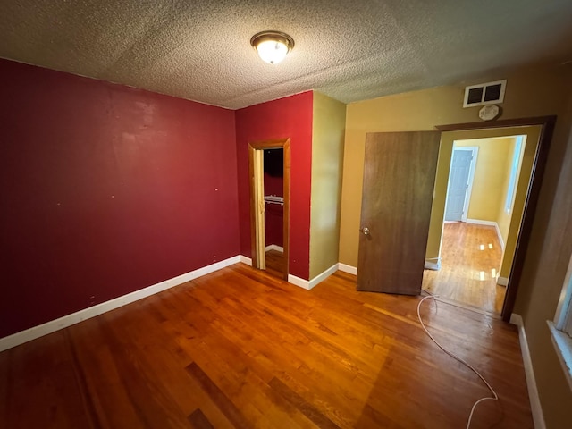 17864 County Road 66 NE, Eagle Bend, MN 56446 - unfurnished bedroom featuring wood finished floors and a textured ceiling