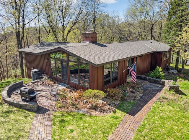 11 Eagle Ridge Rd, North Oaks, MN 55127 - exterior space featuring a shingled roof, a fire pit, a chimney, and a lawn