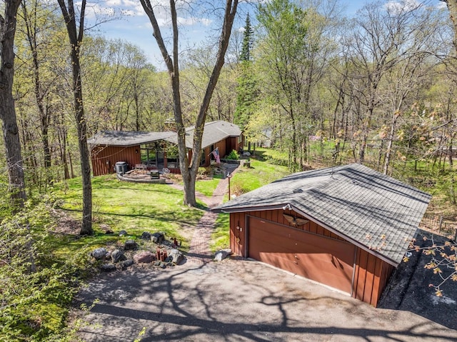 11 Eagle Ridge Rd, North Oaks, MN 55127 - view of green lawn featuring an outdoor structure, a detached garage, and a wooded view