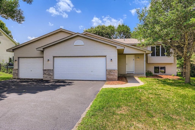 703 11th Ave SW, Isanti, MN 55040 - tri-level home with asphalt driveway, brick siding, an attached garage, and a front lawn