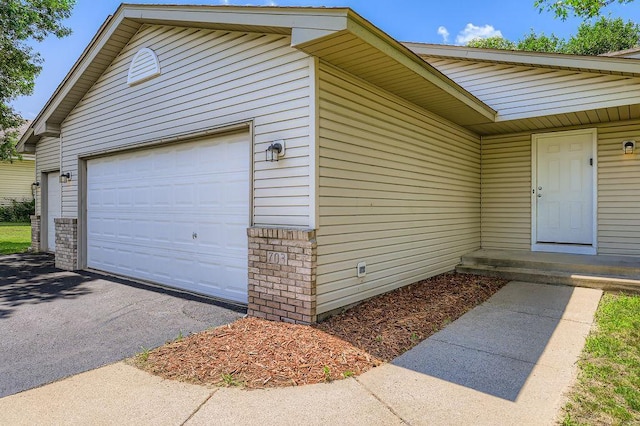 703 11th Ave SW, Isanti, MN 55040 - garage featuring asphalt driveway