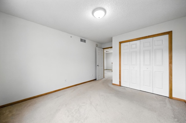 12240 Urbank St NE Unit G, Blaine, MN 55449 - unfurnished bedroom featuring carpet, a textured ceiling, and a closet