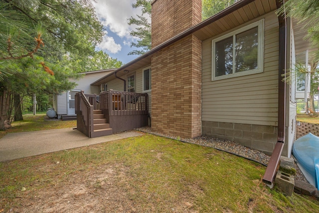 3925 Plainview Dr NW, Hackensack, MN 56452 - view of side of property with a chimney, a deck, a patio, and a lawn